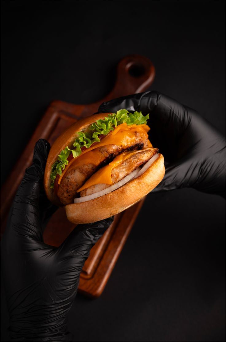 Chicken Buzz: sobrecoxa grelhada com cheddar, alface crespa e cebola, segurado com luvas pretas